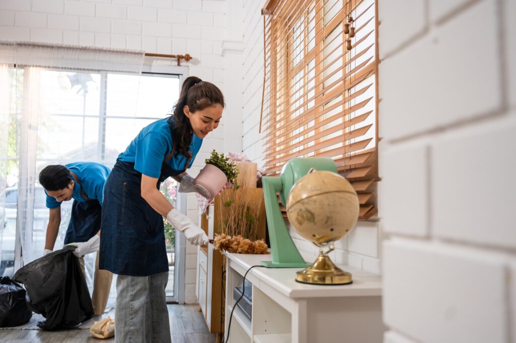 Asian young man and woman cleaning service worker work in living room.